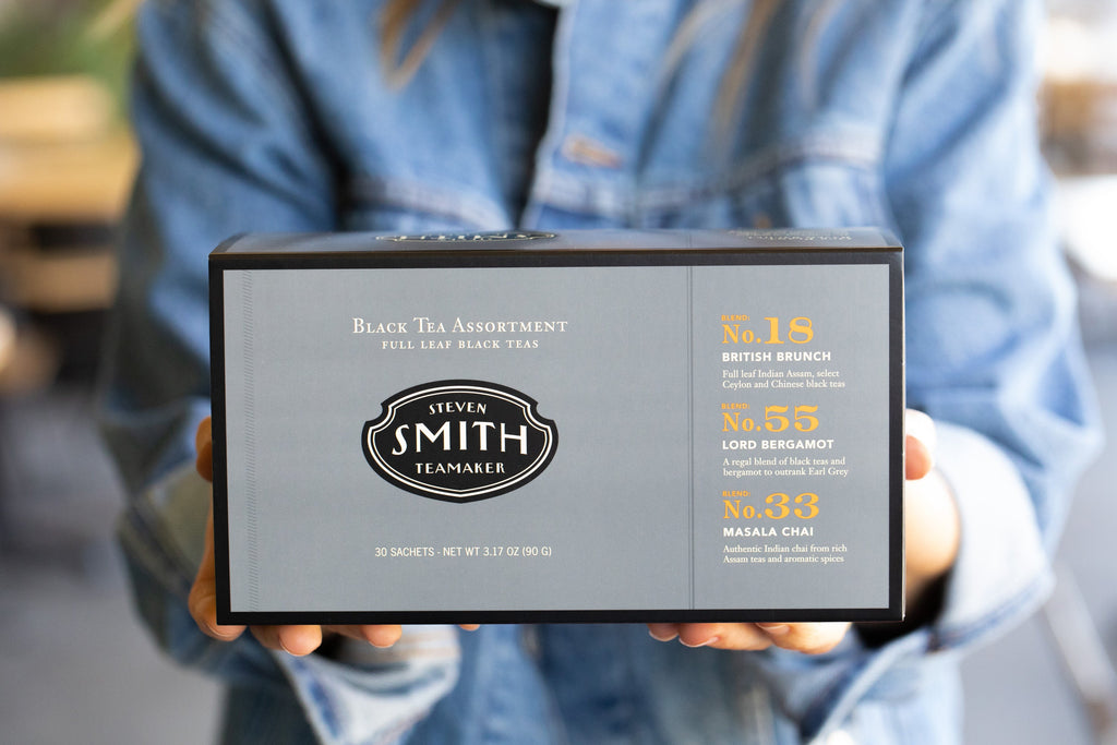 Person holding grey box with black trim.
